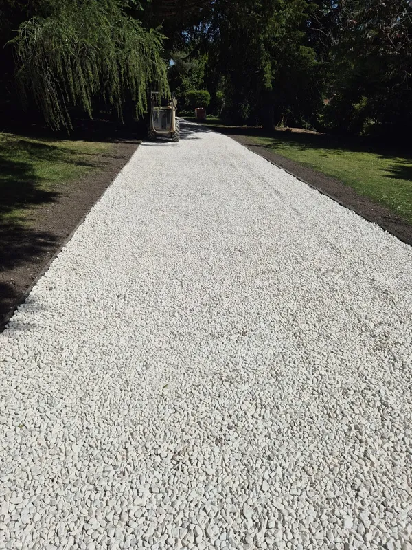 Newly laid gravel driveway leading to a house